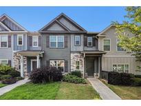 Charming townhome featuring stone accents, a well-manicured lawn, and a welcoming entrance at 255 Orchard Dr, Covington, GA 30014