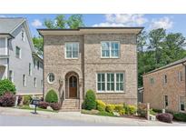 Charming two-story brick home with arched entry, manicured landscaping, and bright windows at 5971 Brundage Lane, Norcross, GA 30071