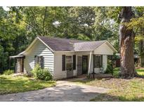Charming home exterior showcasing the front yard and a mature tree providing shade at 1151 Sheppard Pl, Stone Mountain, GA 30083