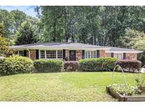 Charming brick home with manicured lawn and mature trees provides great curb appeal at 1747 Remington Rd, Atlanta, GA 30341