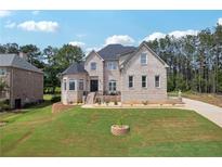 Stunning two-story brick home with a well-manicured lawn and mature trees, offering classic elegance and curb appeal at 2548 Westchester Se Way, Conyers, GA 30013