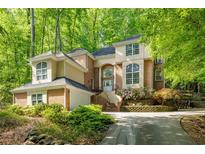Elegant two-story home featuring brick and stucco with a lush landscaped front yard at 815 Marshview Close, Roswell, GA 30076