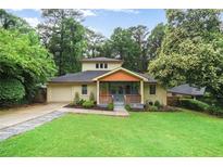 Charming two-story home featuring a lush lawn, covered porch, and attached garage at 1653 Terry Mill Se Rd, Atlanta, GA 30316