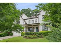 Charming two-story brick home featuring a beautifully landscaped front yard and inviting front porch at 2460 Drew Valley Ne Rd, Brookhaven, GA 30319