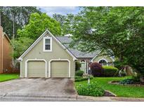 Charming exterior view of home with a two-car garage, manicured lawn, and attractive landscaping at 4710 Vineyard Se Ct, Smyrna, GA 30082