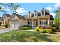 Charming two-story home featuring dormer windows, a covered porch, and well-maintained landscaping at 150 Northshore Xing, Dallas, GA 30157