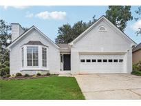 Charming one-story home with a two-car garage, brick exterior, and well-manicured lawn at 645 Ruxbury Ct, Suwanee, GA 30024