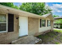 Charming single-story home featuring a brick facade, white door and black shutters and inviting curb appeal at 6516 Maddox Rd, Morrow, GA 30260
