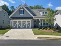 Charming single-Gathering home featuring a two-car garage, well-manicured lawn, and inviting curb appeal at 1534 Bedstone Drive Dr, Canton, GA 30114