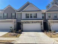 Charming townhome featuring a two-car garage and landscaped front yard at 2314 Shetley Creek Dr, Norcross, GA 30071