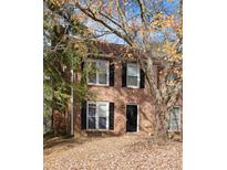 Charming two-story brick home featuring black shutters, large windows, and a front yard covered in colorful fall leaves at 687 Redland Dr # 687, Riverdale, GA 30238