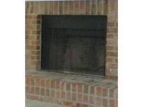Close-up of a traditional brick fireplace with a black firebox at 687 Redland Dr # 687, Riverdale, GA 30238