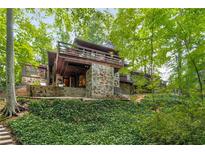 Unique home nestled in a lush, wooded setting offers privacy and scenic views from the upper level deck at 2016 Castleway Ne Dr, Atlanta, GA 30345
