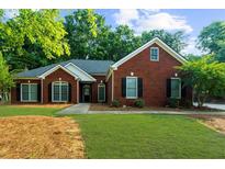 Charming brick home with well-maintained lawn and classic architectural details at 7610 Golden Sands Dr, Cumming, GA 30041