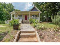 Charming home with a welcoming porch, landscaped front yard, and inviting red front door at 58 Bisbee Se Ave, Atlanta, GA 30315