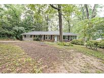 Charming brick home featuring a well-maintained front yard with mature trees and a cozy, inviting exterior at 1327 Rupert Rd, Decatur, GA 30030