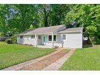 Charming single-story home featuring a well-maintained lawn, painted brick, and a cute front porch at 1735 Carter Cir, Atlanta, GA 30344