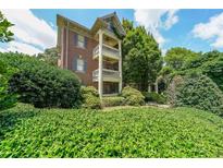 Three-story brick condo featuring private balconies, lush landscaping and classic architectural details at 2 Collier Nw Rd # 5, Atlanta, GA 30309