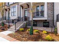 Charming brick townhome featuring a front porch, landscaped garden and black metal railings at 540 Fisher Dr # 46, Alpharetta, GA 30009