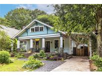 Charming two-story home with a landscaped front yard, welcoming porch, and private driveway with a covered parking area at 570 Park Se Ave, Atlanta, GA 30312
