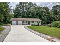 Charming ranch-style home with a long driveway and well-manicured lawn at 905 Hickory Ridge Sw Rd, Lilburn, GA 30047
