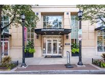 Inviting building entrance featuring brick facade, planters, and clear signage for Museum Tower at 285 Centennial Olympic Park Nw Dr # 1407, Atlanta, GA 30313