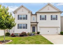 Charming two-story home featuring white siding, blue shutters, and a well-manicured lawn at 4000 Red Canoe Bnd, Lilburn, GA 30047