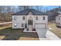 Beautiful two-story home with a brick facade, arched entryway, and two-car garage at 4400 Ross Estates Ct, Snellville, GA 30039