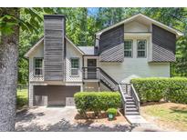 Charming home with a unique exterior, landscaped front yard, and attached garage at 1575 Barrier Rd, Marietta, GA 30066