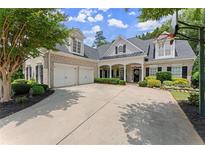 Traditional brick home with a manicured lawn, two-car garage, and charming covered front porch at 956 Kinghorn Nw Dr, Kennesaw, GA 30152