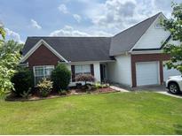 Charming single-story home featuring a well-manicured lawn, brick accents, and a two-car garage at 2256 Hansford Pass, Buford, GA 30519
