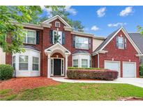 Charming two-story brick home featuring a well-manicured lawn and symmetrical design at 3065 Moser Way, Marietta, GA 30060