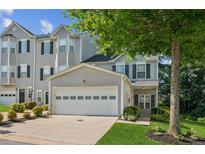 Attractive townhome featuring a two-car garage, classic siding, and landscaped front yard at 1714 Indian Way, Cumming, GA 30040