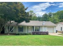 Charming single-story home with a well-manicured lawn and inviting front porch with light blue shutters at 1150 Terramont Dr, Roswell, GA 30076