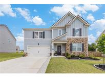 Charming two-story home featuring a stone facade, inviting front porch, well-maintained lawn, and attached two car garage at 36 Ivy Chase Loop, Dallas, GA 30157