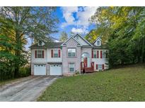 Charming two-story home featuring a brick facade, red shutters, and a well-manicured front lawn at 9444 Lakeview Ct, Douglasville, GA 30135