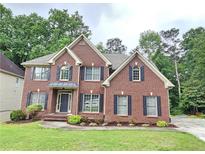 Charming two-story brick home with a well-maintained lawn and mature trees at 1988 Greensferry Gln, Lawrenceville, GA 30043