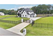 Beautiful two-story home with a black fence, a long driveway, and a well-manicured lawn at 2243 Cain Cir, Dacula, GA 30019