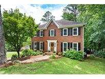 Traditional brick home with black shutters and a well-manicured lawn at 4522 Reva Ne Ct, Marietta, GA 30066
