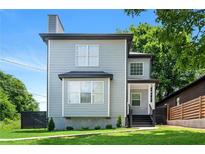 Charming two-story home with gray siding, black trim, and a well-manicured lawn in a desirable neighborhood at 900 Ira Sw St, Atlanta, GA 30310