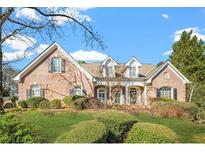 Charming brick home with a manicured lawn and mature trees under a bright blue sky at 1561 Annapolis Way, Grayson, GA 30017
