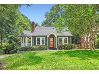 Charming bungalow featuring a brick chimney, inviting front porch, and lush lawn at 1134 Jefferson Ave, East Point, GA 30344