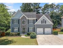 Charming two-story home featuring stone accents, a two-car garage, and a well-maintained lawn at 2081 Township Dr, Woodstock, GA 30189
