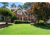 Beautifully landscaped front yard featuring a well-maintained lawn and mature trees at 410 Beechwood Ln, Woodstock, GA 30189