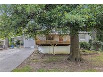Charming home featuring a large wooden deck and an ample-sized front yard surrounded by lush trees at 726 Alfred Nw Rd, Atlanta, GA 30331