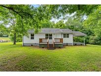 Charming home featuring a well-maintained lawn, inviting entryway, and a classic carport offering a welcoming curb appeal at 1179 Chatham Rd, Buford, GA 30518