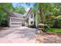 Charming home with stone accents, an attached garage, and well-maintained landscaping in a serene, wooded setting at 4341 Horder Ct, Snellville, GA 30039