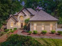 Stunning two-story home features a lush landscaped yard, stone pathway, and elegant architectural details at 2505 Ridgehurst Dr, Buford, GA 30518