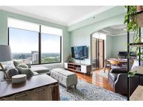 Bright living room with hardwood floors, large windows, and views of the cityscape, open to dining area at 3445 Stratford Rd # 3102, Atlanta, GA 30326