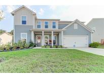Charming two-story home with a well-manicured lawn, covered entryway, and attached garage at 230 Mackenzie Ct, Covington, GA 30016